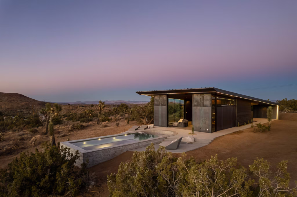 Obsidian Joshua Tree luxury Airbnb in Yucca Valley with an infinity-edge pool, mirrored sauna, minimalist architecture, and expansive desert boulder views.