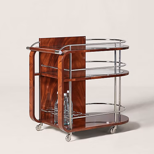 Ralph Lauren Home Duke Bar Cart with polished stainless steel frame, mahogany handle, glass shelves, casters, and bottle storage for a luxury home bar.