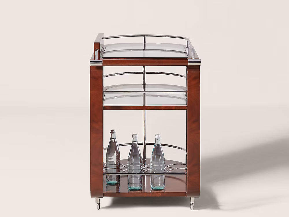 Ralph Lauren Home Duke Bar Cart with polished stainless steel frame, mahogany handle, glass shelves, casters, and bottle storage for a luxury home bar.