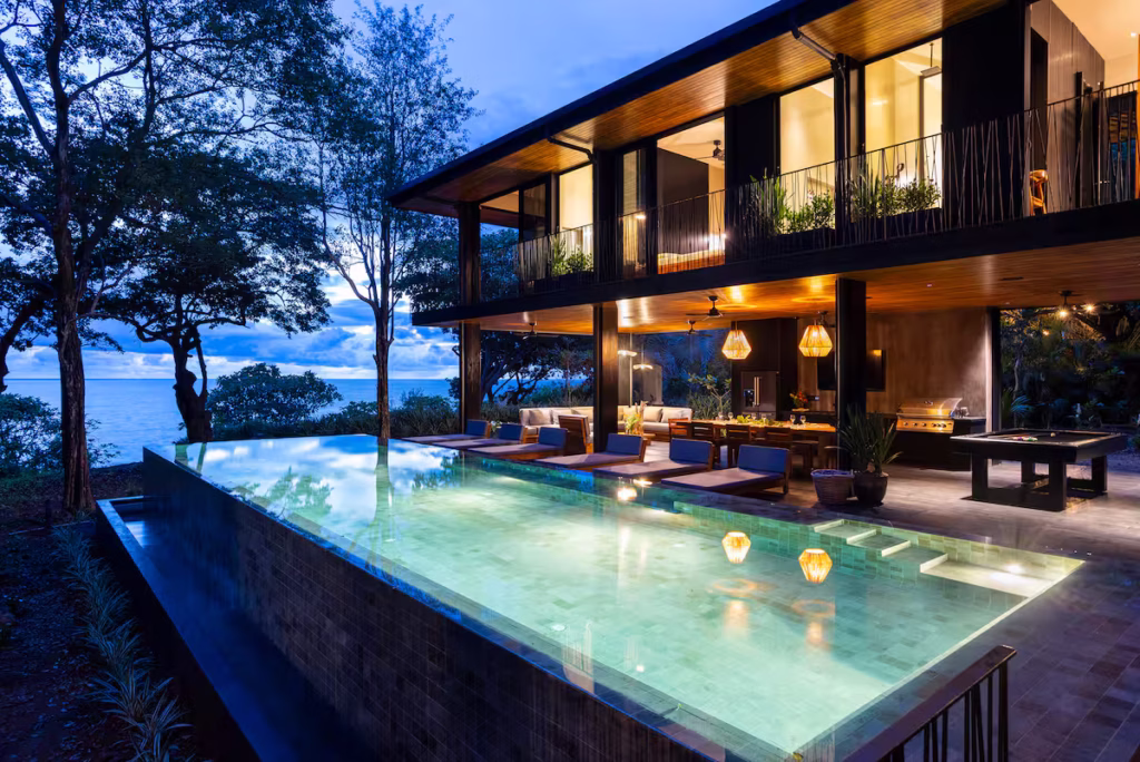 Casa Perla Negra villa in Puerto Carrillo Costa Rica with dark modern architecture, forest surroundings, Pacific views, and an infinity pool.