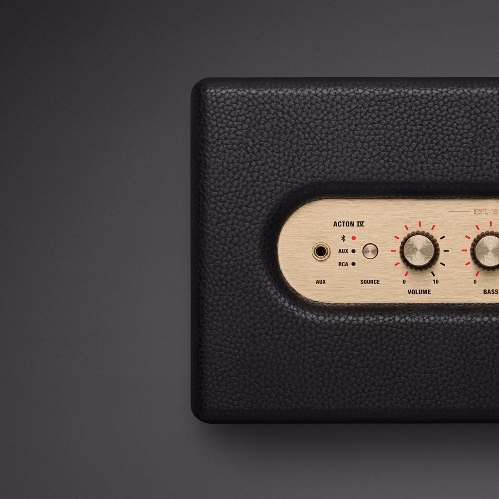 Marshall Acton IV wireless speaker in black with gold accents against a dark background.