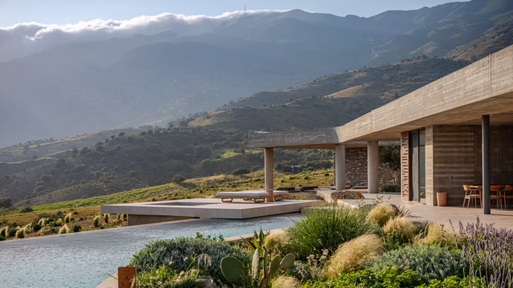 Keras Cliff House in Crete set into the hillside with modern concrete architecture and mountain views