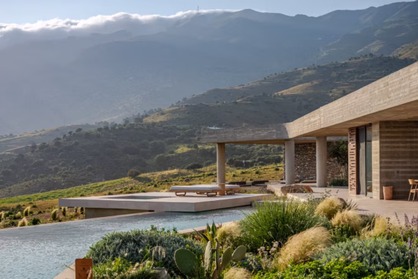 Keras Cliff House in Crete set into the hillside with modern concrete architecture and mountain views