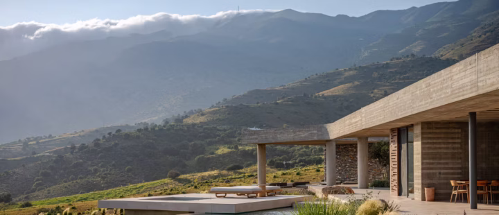 Keras Cliff House in Crete set into the hillside with modern concrete architecture and mountain views