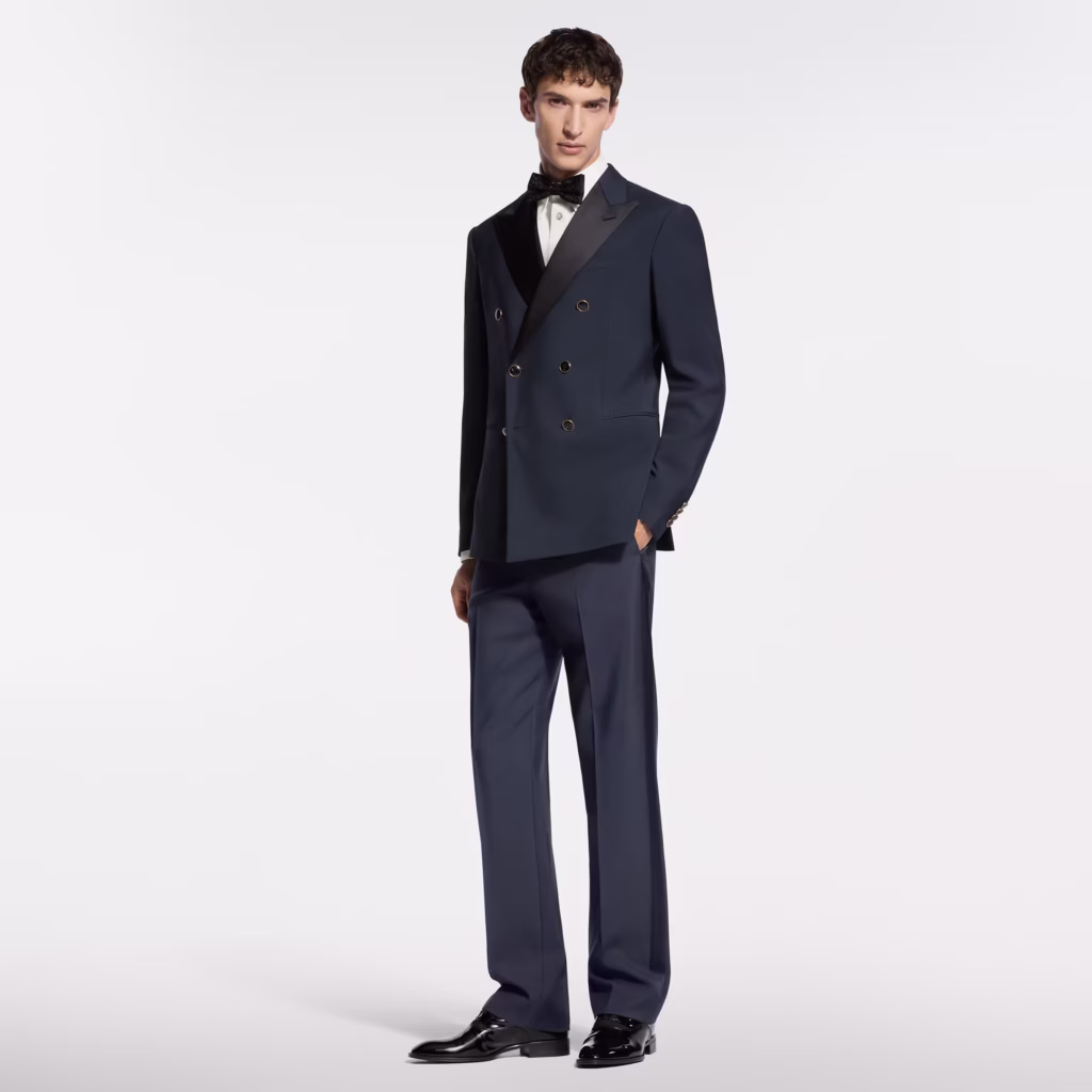 Louis Vuitton model wearing a navy double-breasted tuxedo with satin lapels and black bow tie