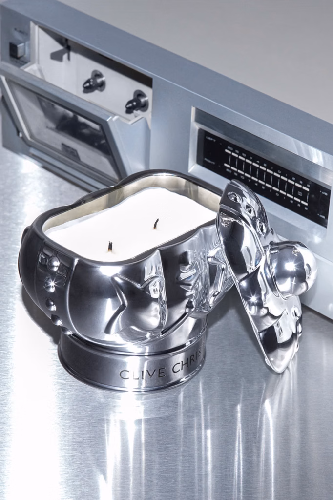 Open silver Clive Christian Fine Objects candle displayed on a vintage stereo receiver.