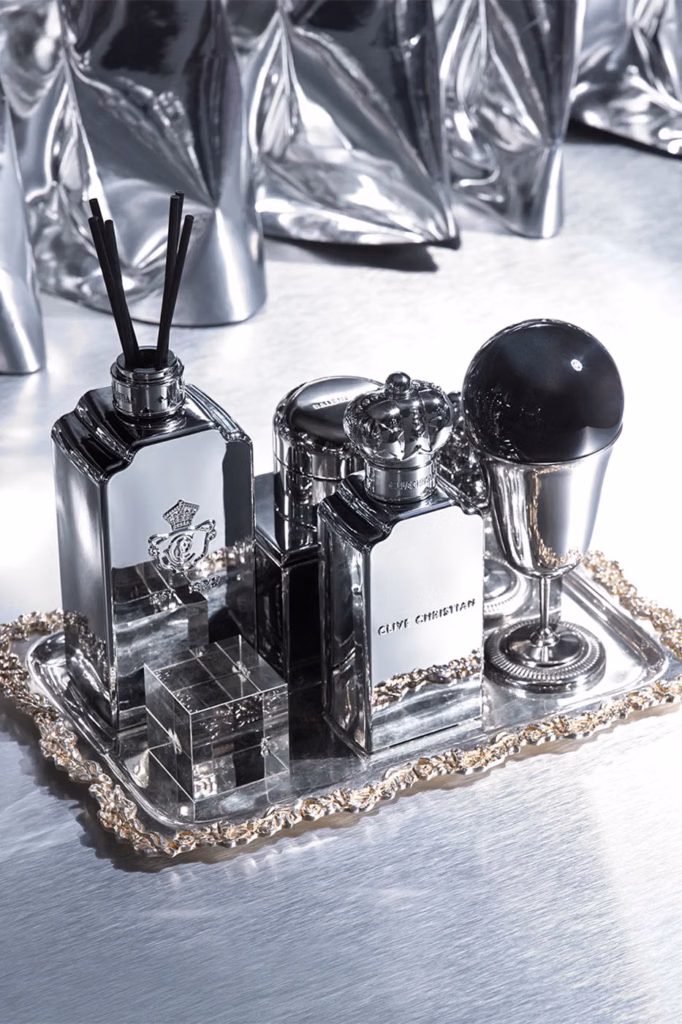 Silver Clive Christian fragrance diffusers and decorative objects arranged on an ornate serving tray.
