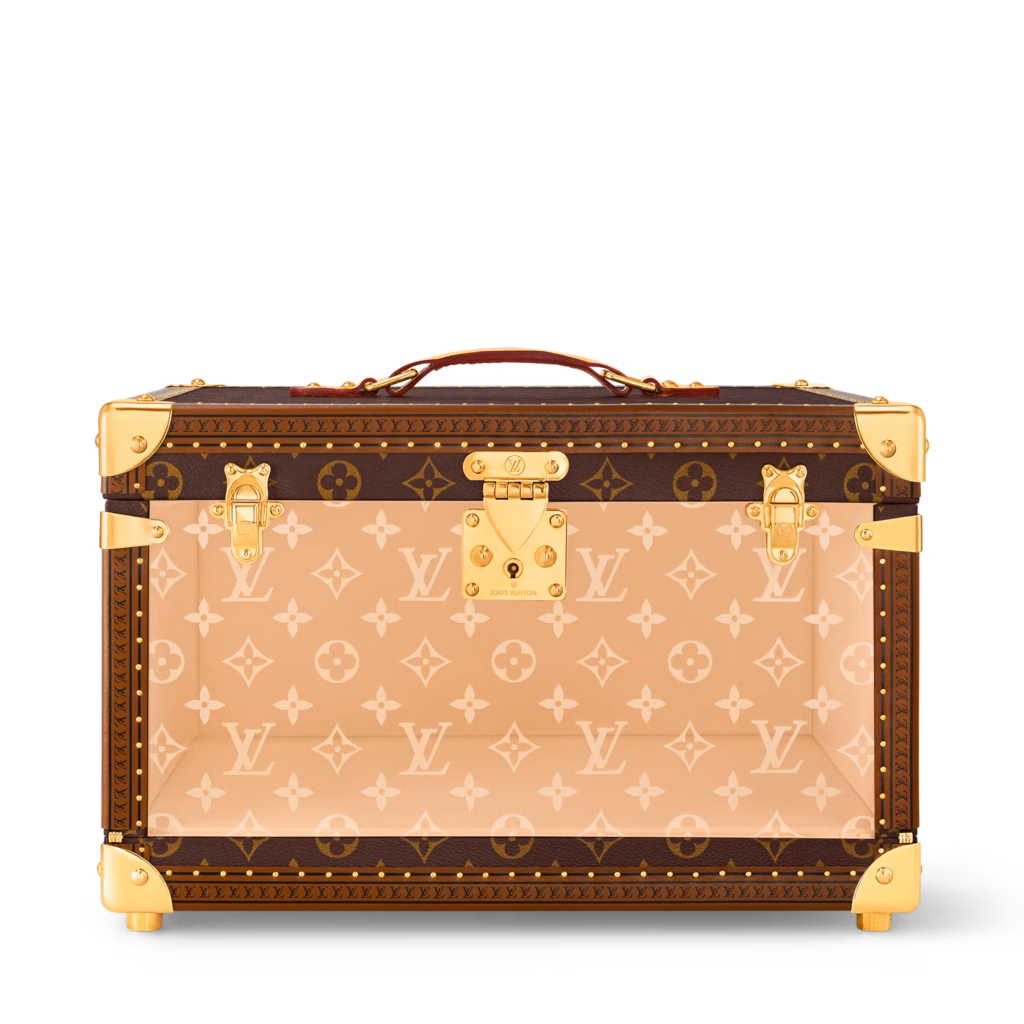 Front view of the Louis Vuitton Shoe Box Monogram trunk with a transparent patterned panel, leather handle and gold-tone lock.